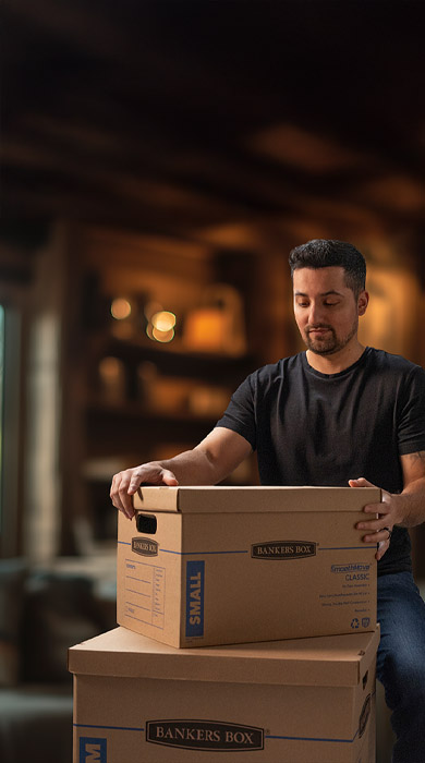 A man looking at a stack of moving boxes
