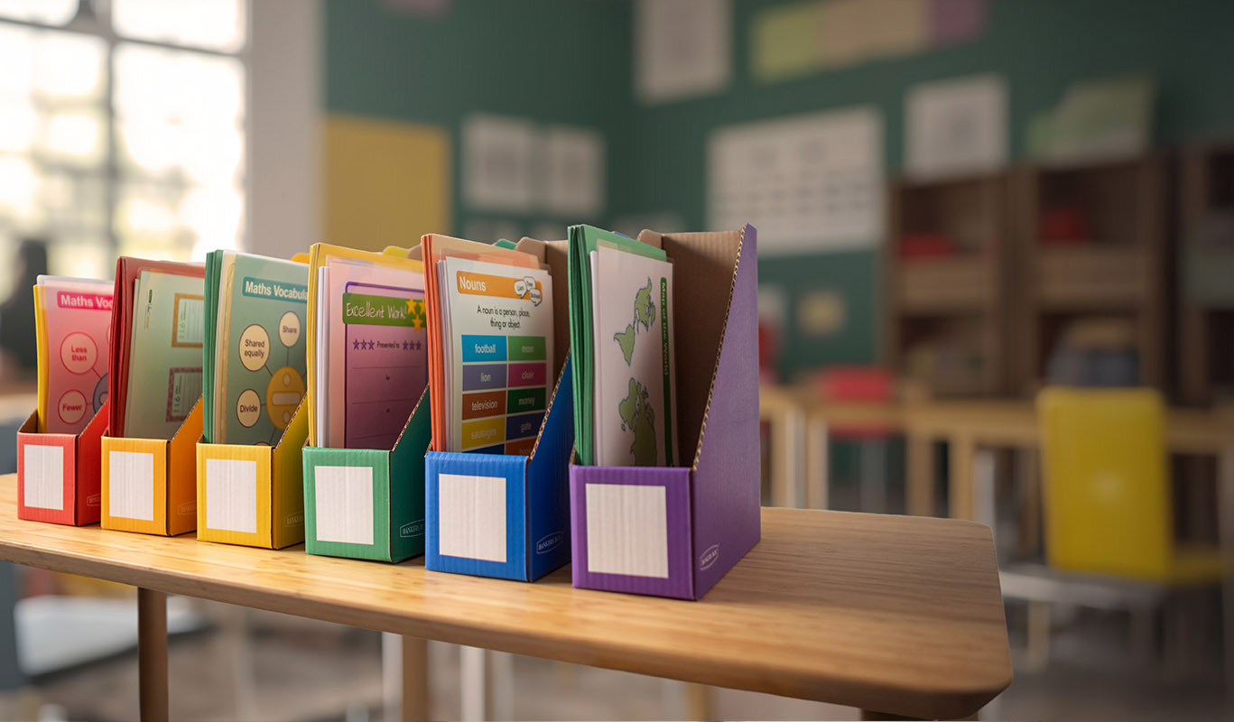 multiple colored file boxes stacked next to each other on a desk