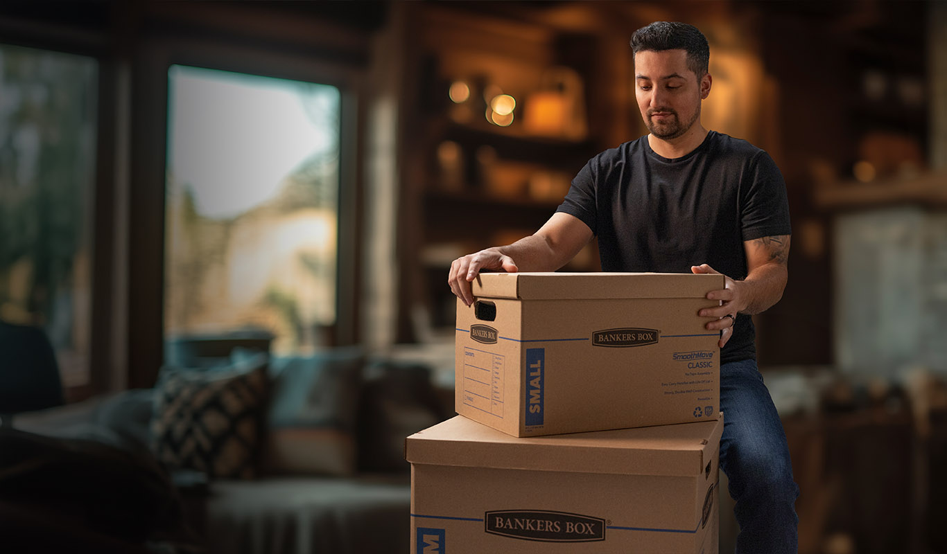 A man looking at a stack of moving boxes