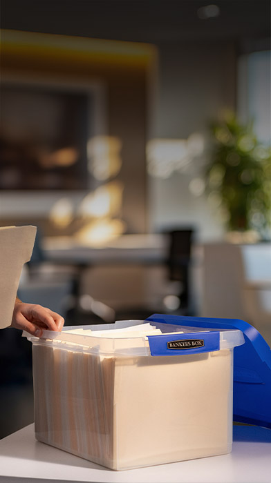 Man looking at a file folder he just took out of a plastic storage box