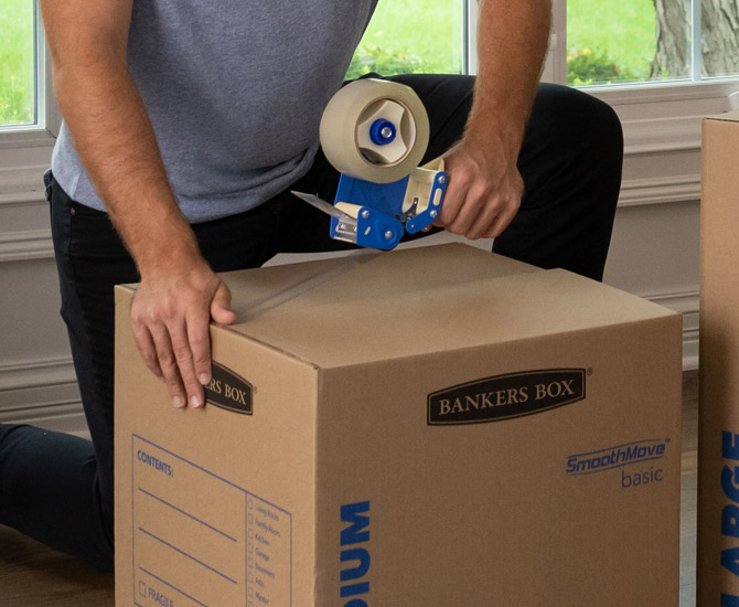 Woman carrying an unassembled box smiling at the camera