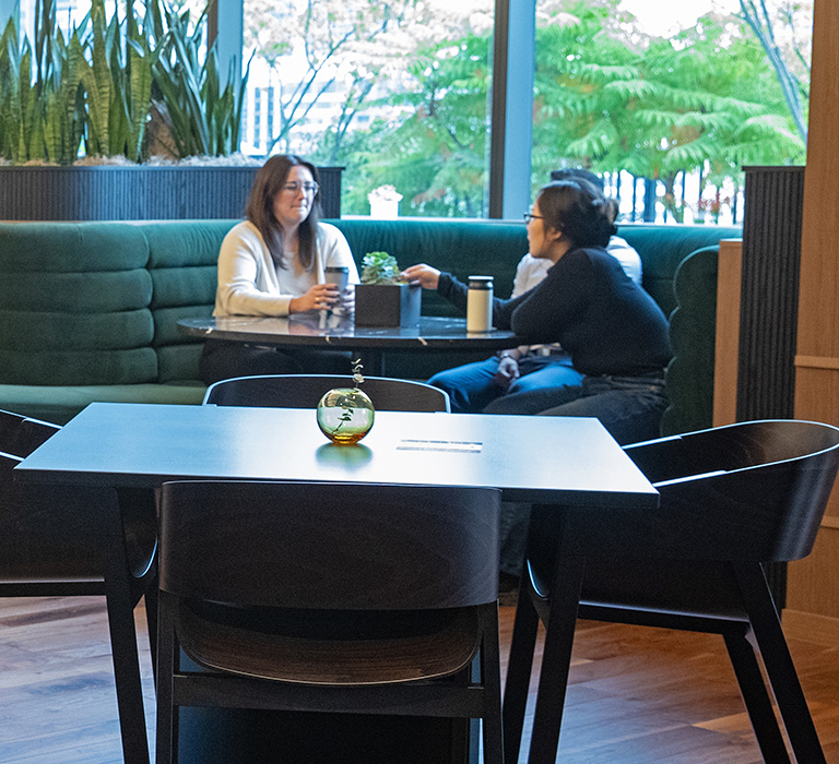 image of people sitting at tables in a company cafeteria talking and eating