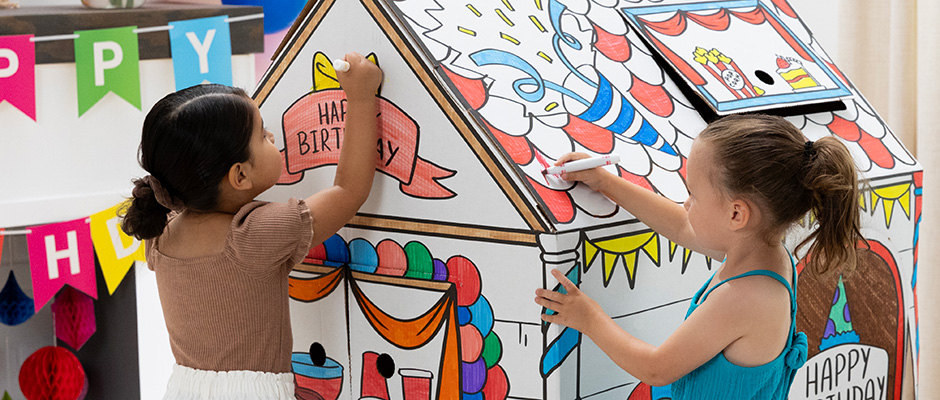 Image of two young girls coloring in a Bankers Box At Play Playhouse