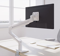 Image of Woman Stood At A Sit-Stand Desk