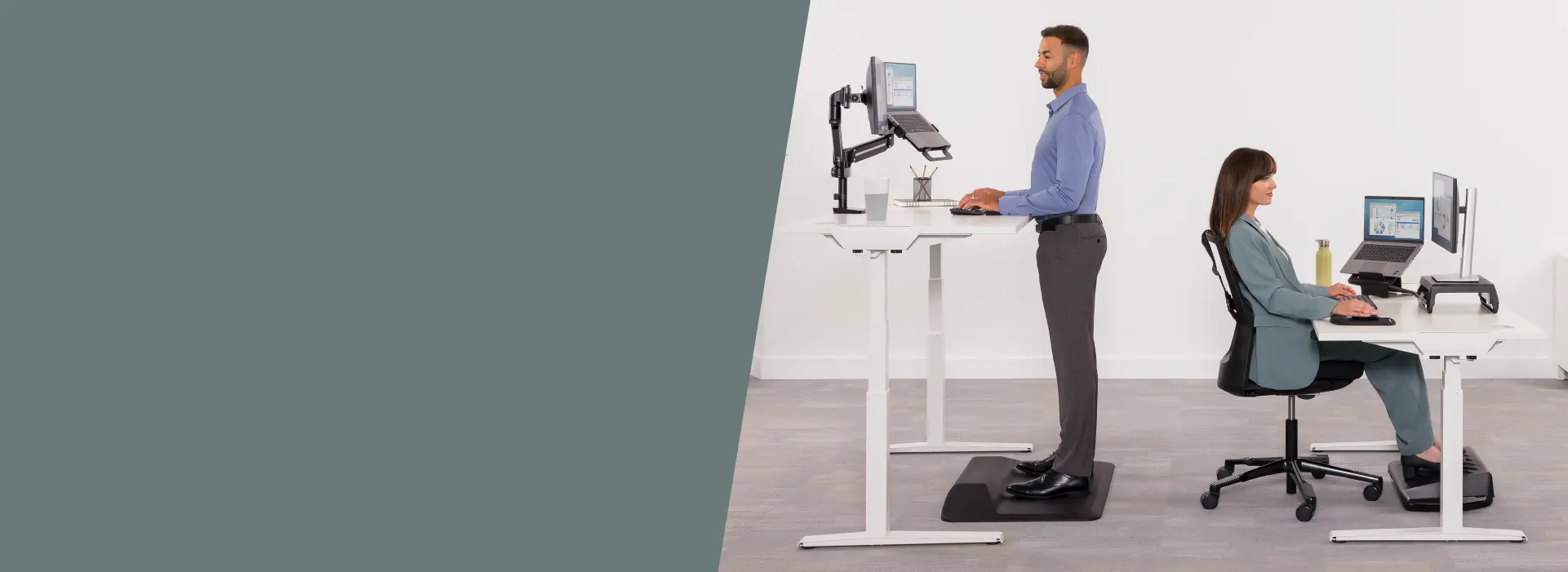 Man stood at a desk and a woman sat at a desk