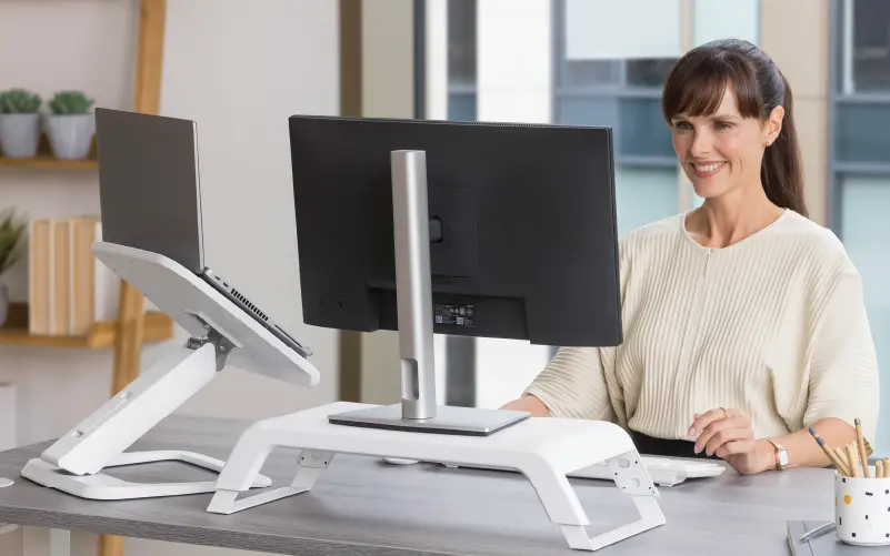 Woman looking at a monitor that sits on a monitor riser