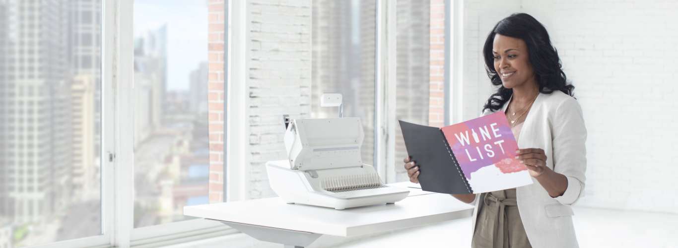 Woman sitting at desk looking off-screen while next to a shredder