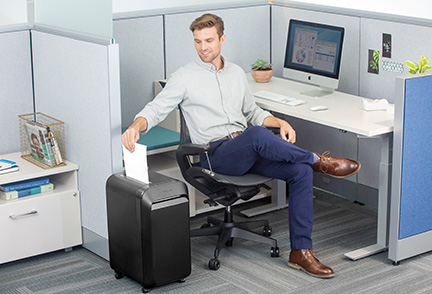 Two men and a woman conversing at desk