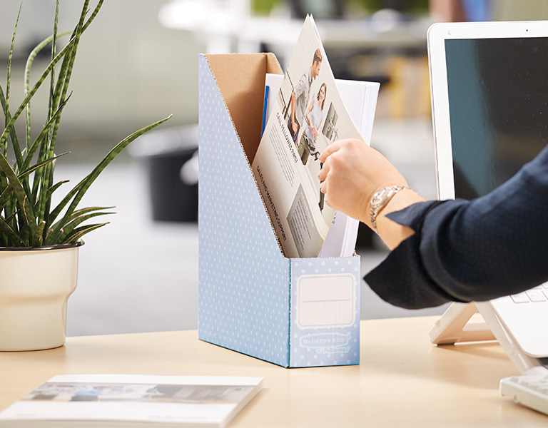 Woman sitting at desk with a magazine file