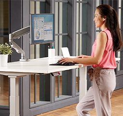 Imagen de una mujer sentada en un escritorio sit-stand