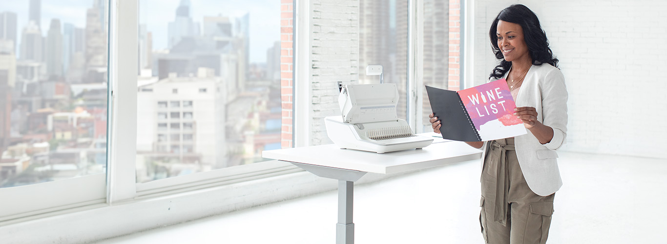 Femme assise à un bureau, regardant en dehors de la photo, à côté d'une déchiqueteuse