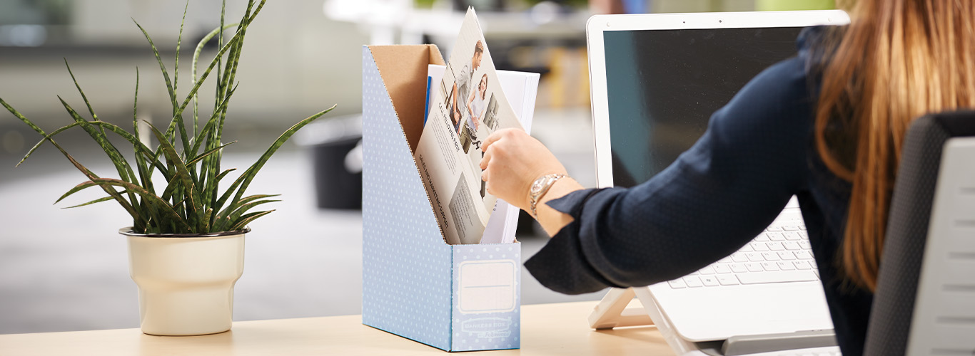 Woman sitting at desk with a magazine file