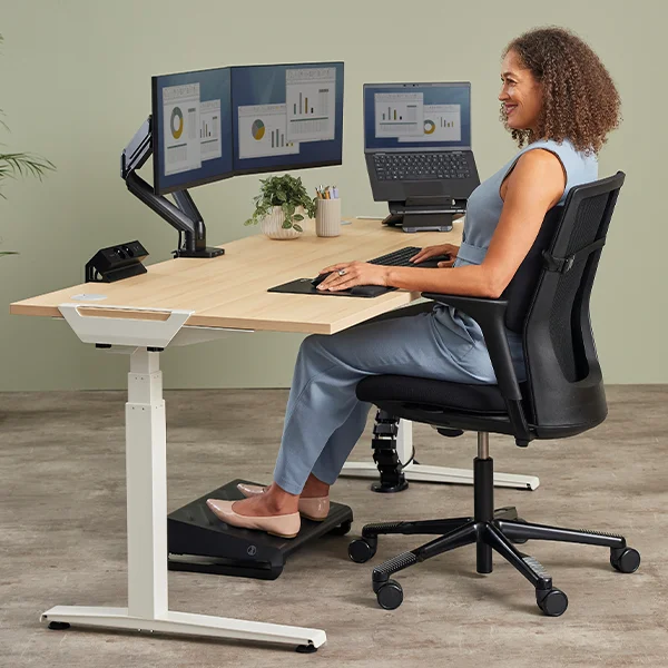 Woman sat at an ergonomic desk set up