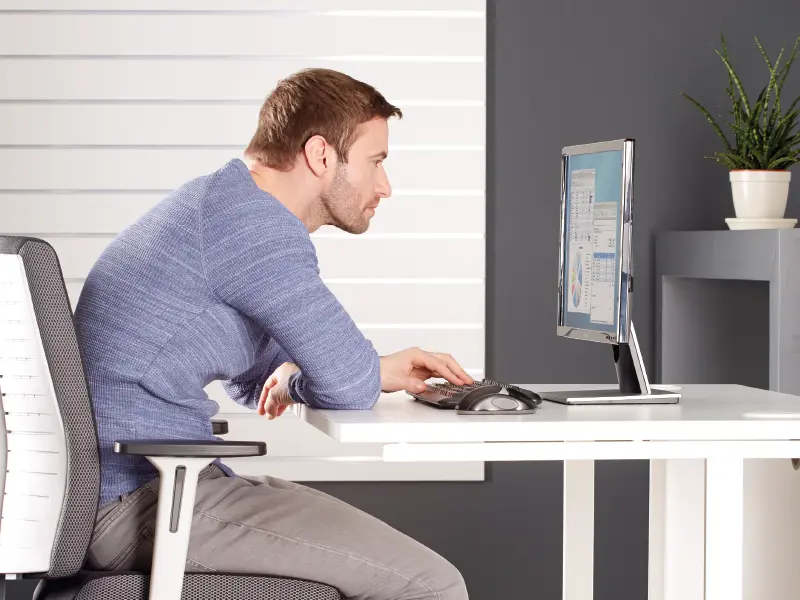 Man slouched over looking at his laptop