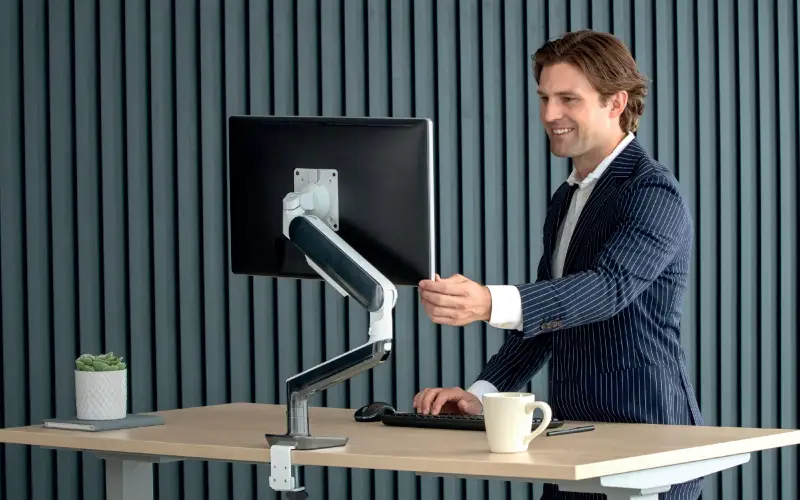 Man adjusting monitor arm