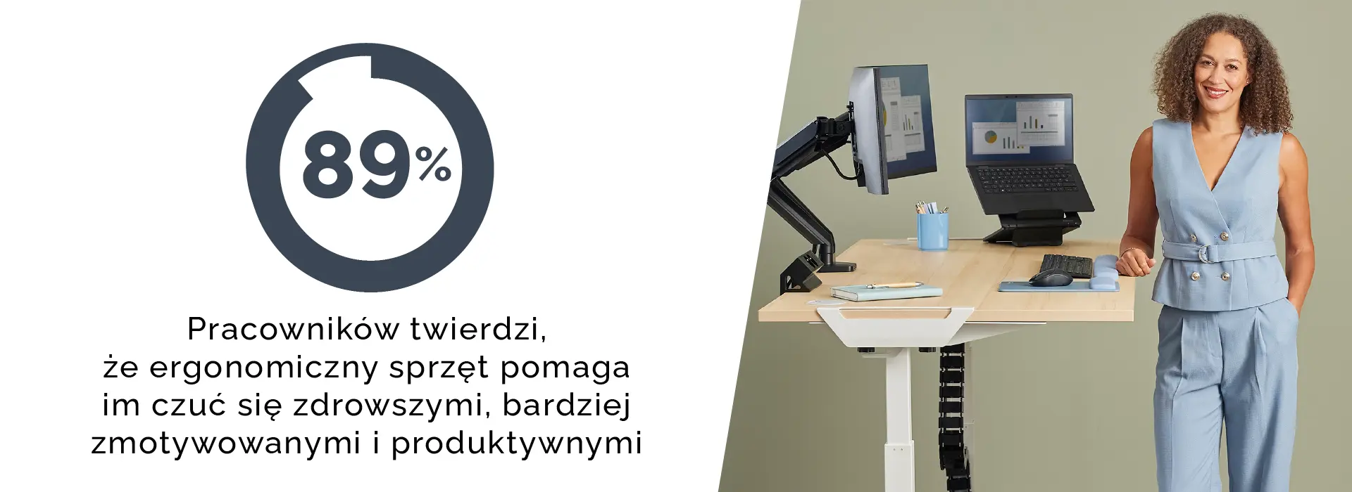 Woman stood beside a sit-stand desk ergonomic set up