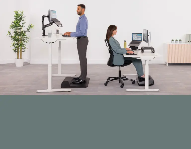 Man stood at a desk and a woman sat at a desk