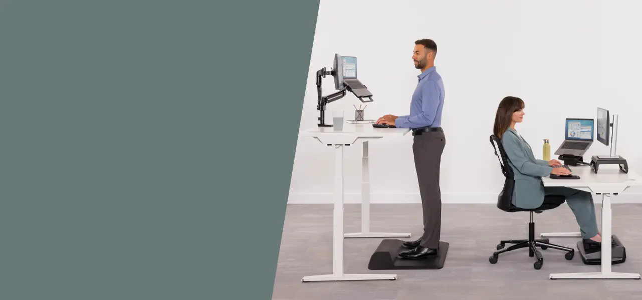 Man stood at a desk and a woman sat at a desk