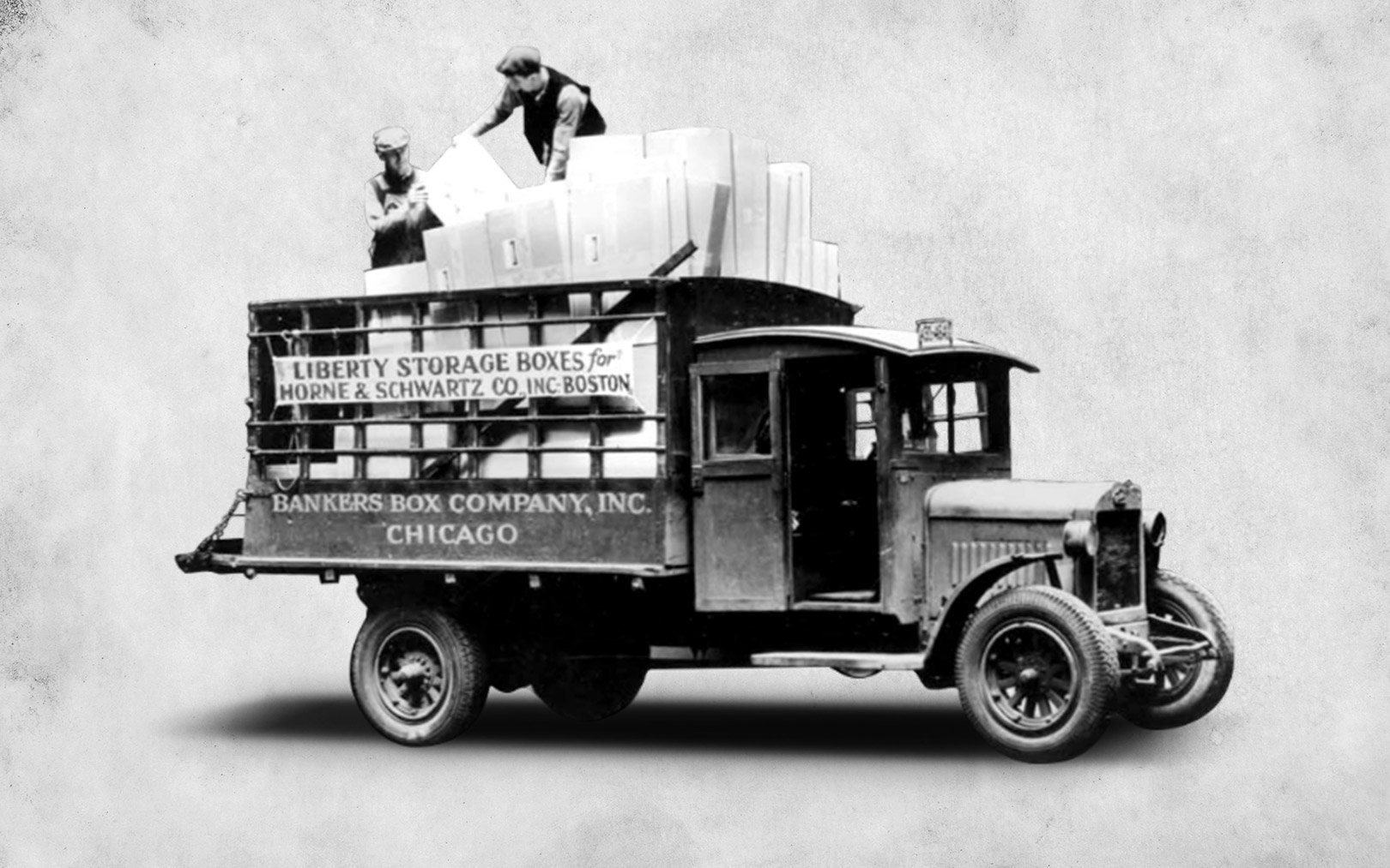 three men standing over a prototype discussing something