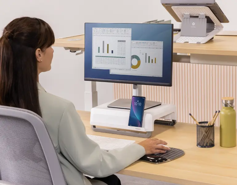 Woman using a monitor riser at a desk