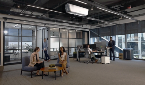 Photo of the inside of an office common space with people conversing