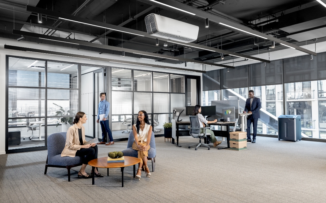 Image of people working and conversing in an office space.