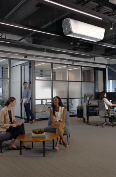 Photo of the inside of an office common space with people conversing