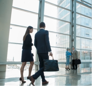 man and woman in business attire walking in an office lobby