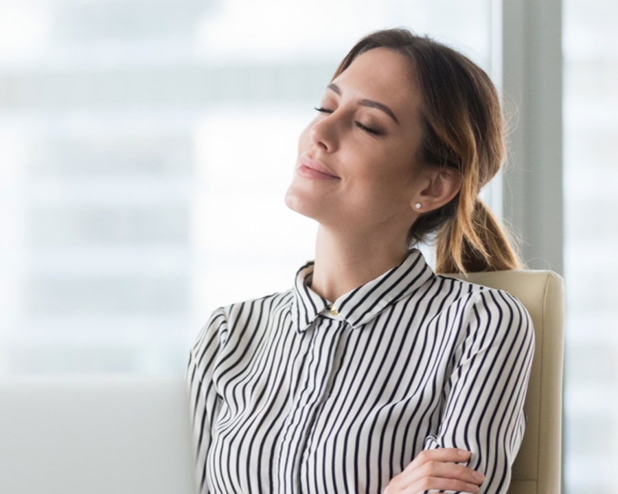 Image of woman with arms crossed, eyes closed, and smiling