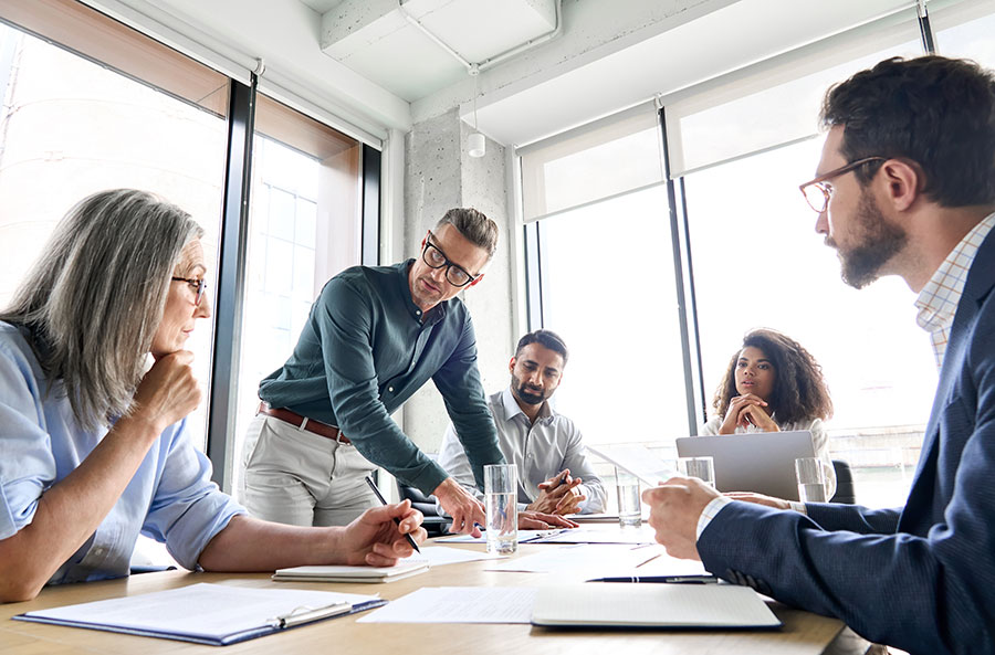 Group of 5 people working around a conference table