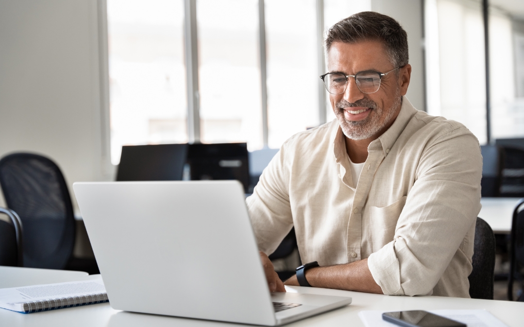 Image of a man working on his laptop in a conference setting