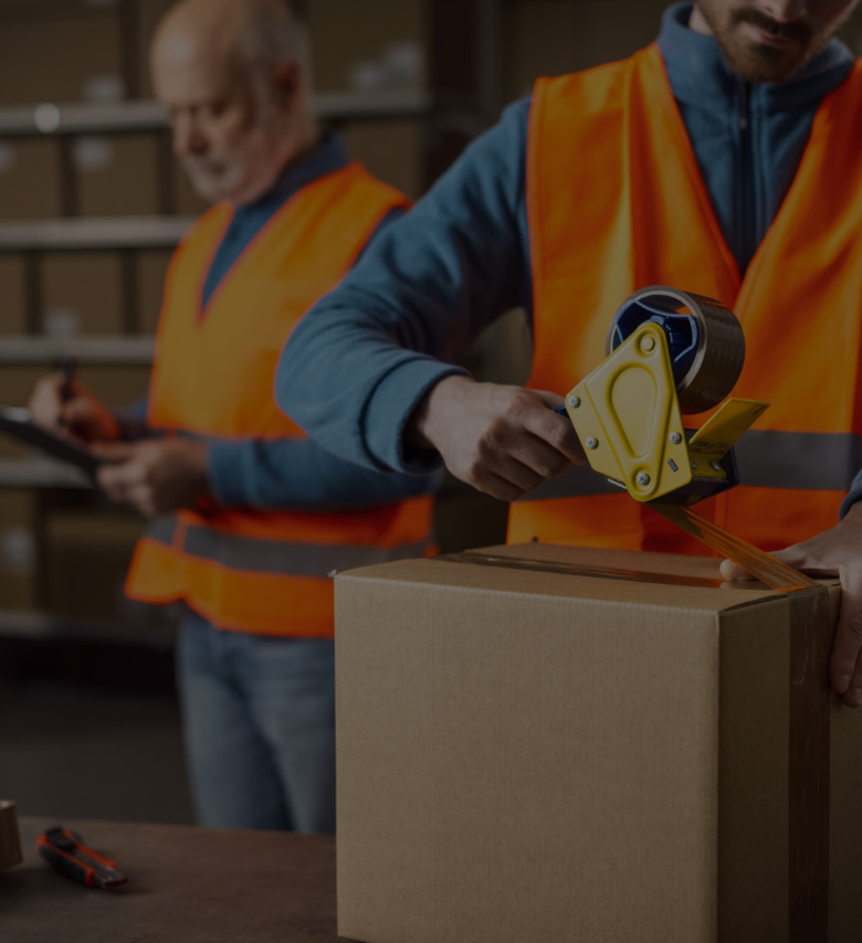 Image of a man taping up a box in a warehouse