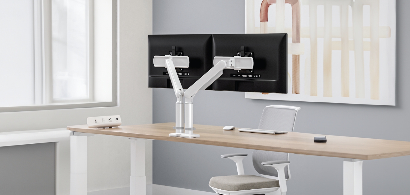 Image of a dual monitor arm attached to a desk