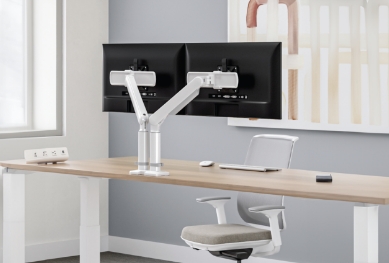 Image of a dual monitor arm attached to a desk
