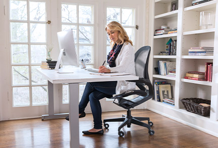 View of a woman sitting in her home office working