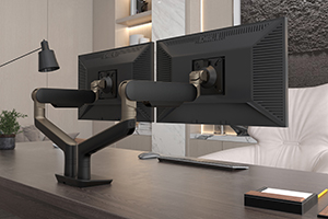 Image of a two screen monitor arm attached to an office desk.
