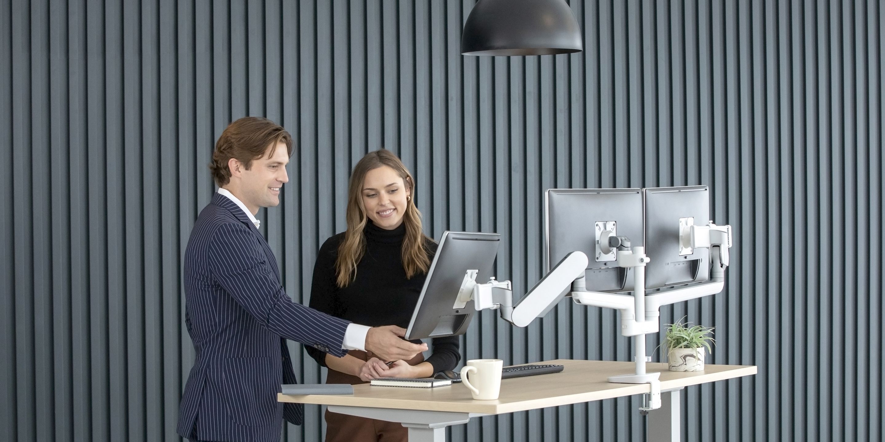 Image of two people looking at a monitor on a desk