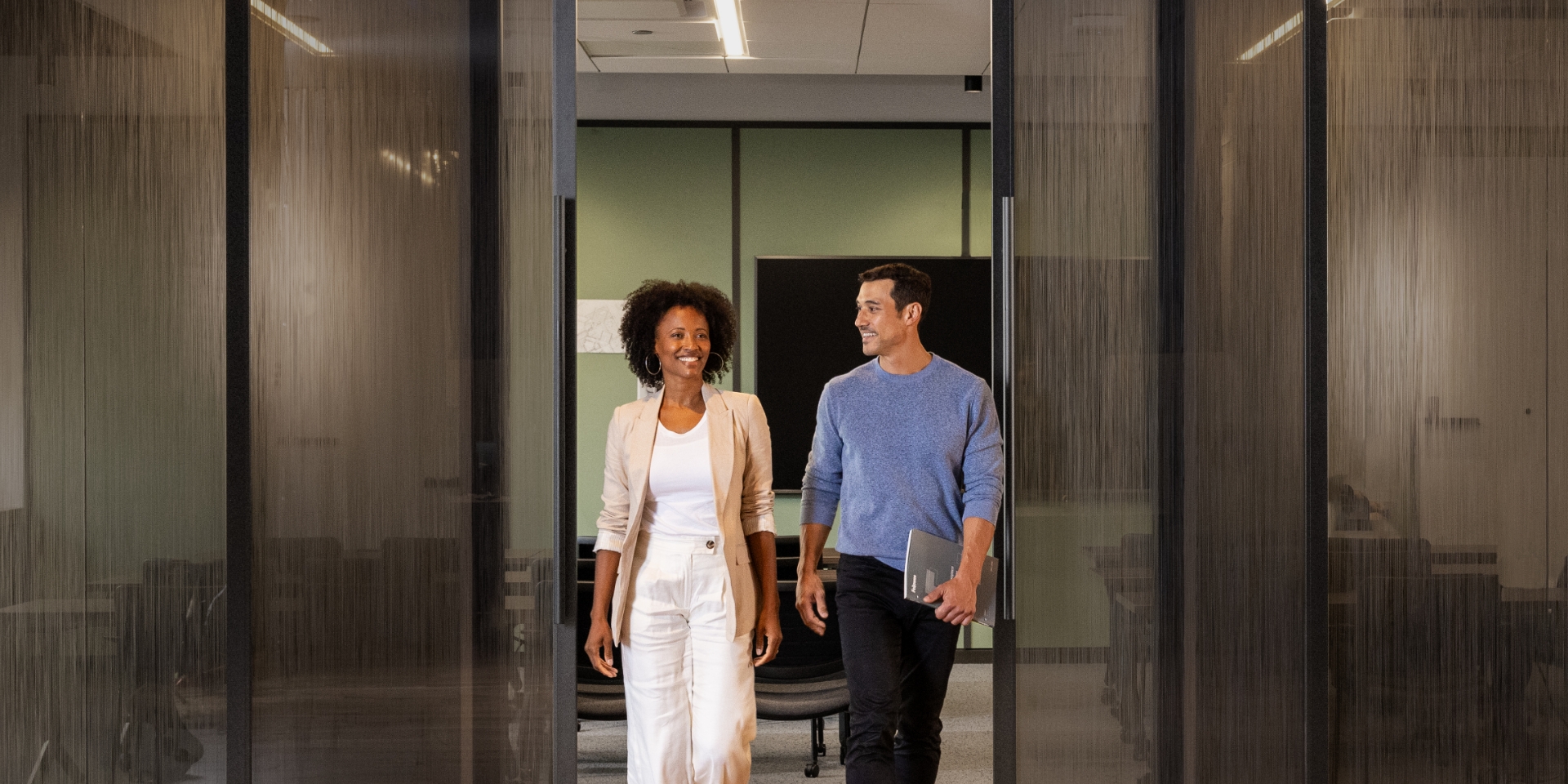 Image of two people looking at a monitor on a desk
