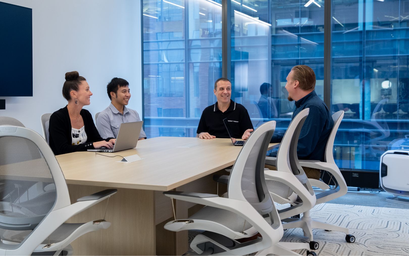 Four people sitting around a conference table talking